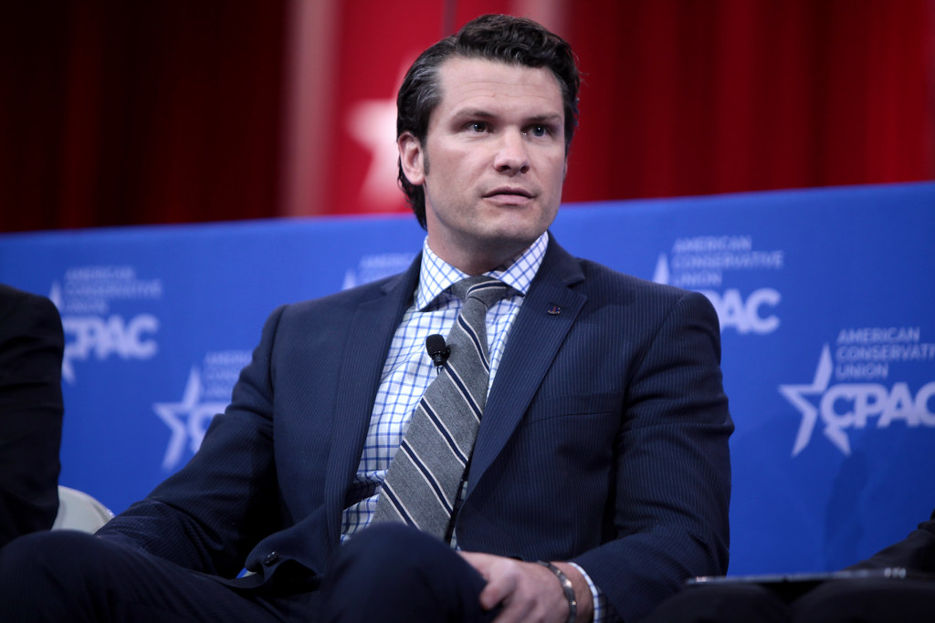 Pete Hegseth speaking at the Pentagon during a religious event, highlighting controversy over quoting a fictional Bible verse from Pulp Fiction in an official setting.